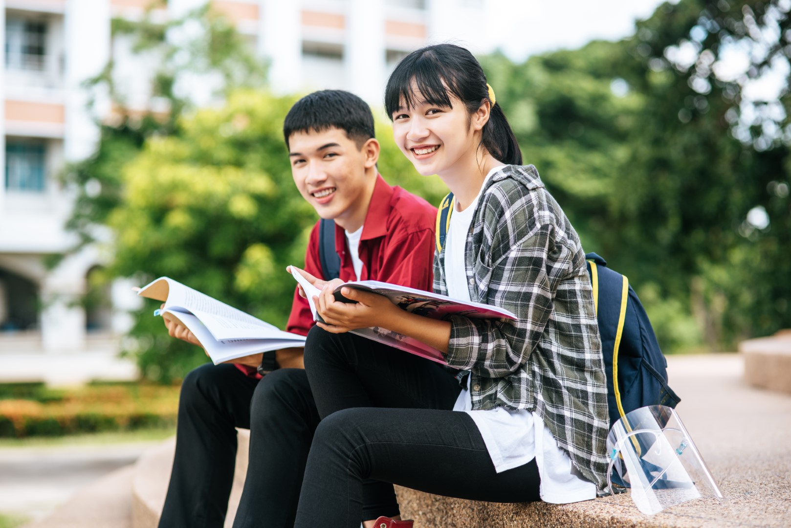 male-female-students-sitting-reading-books-stairs