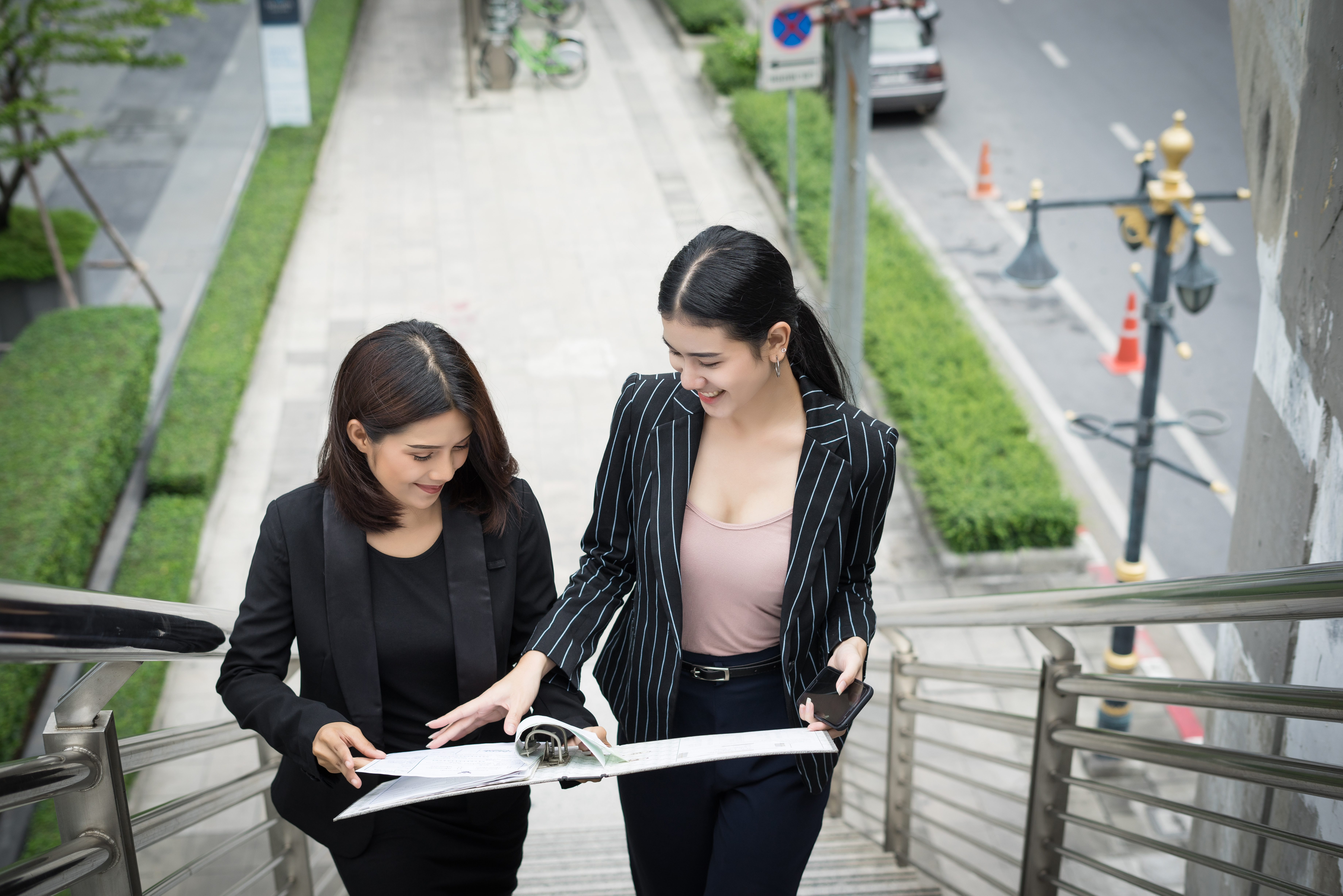 young-asian-businesswomen-with-docuent-walking-stairs